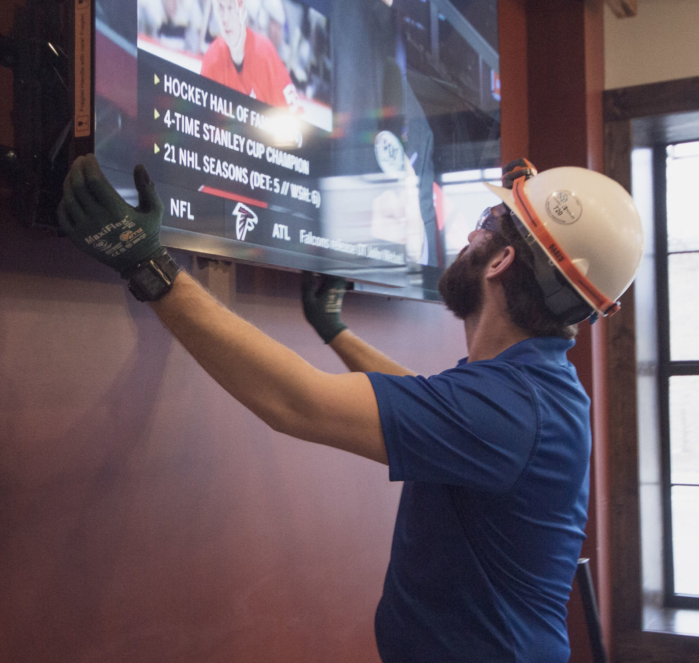 AV technician adjusting a tv