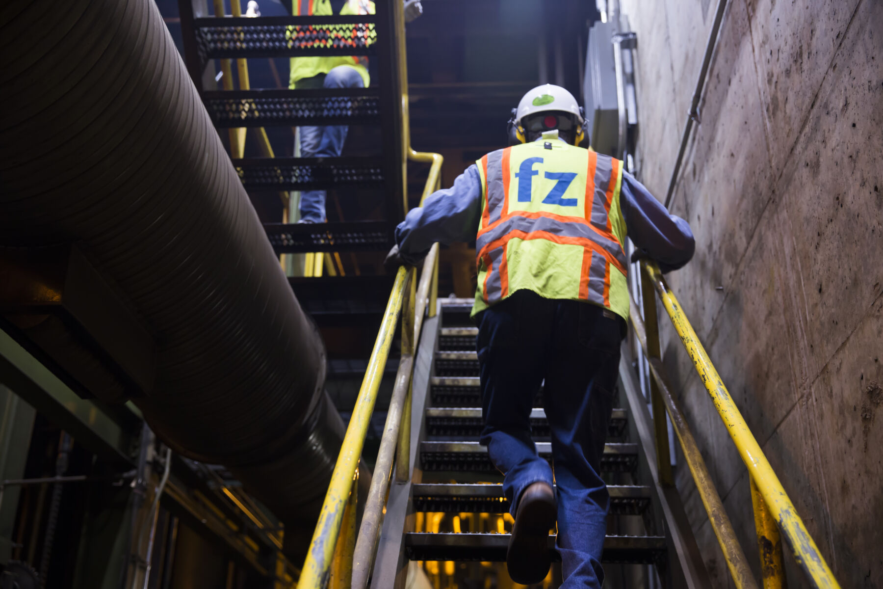 electrician walking up stairs at a facility