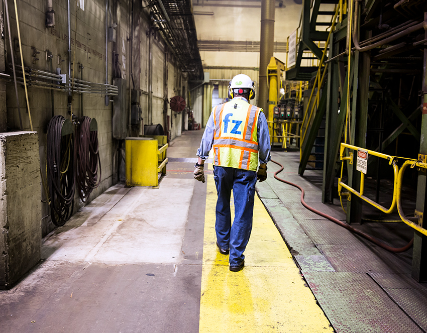electrician walking throughout a manufacturing facility