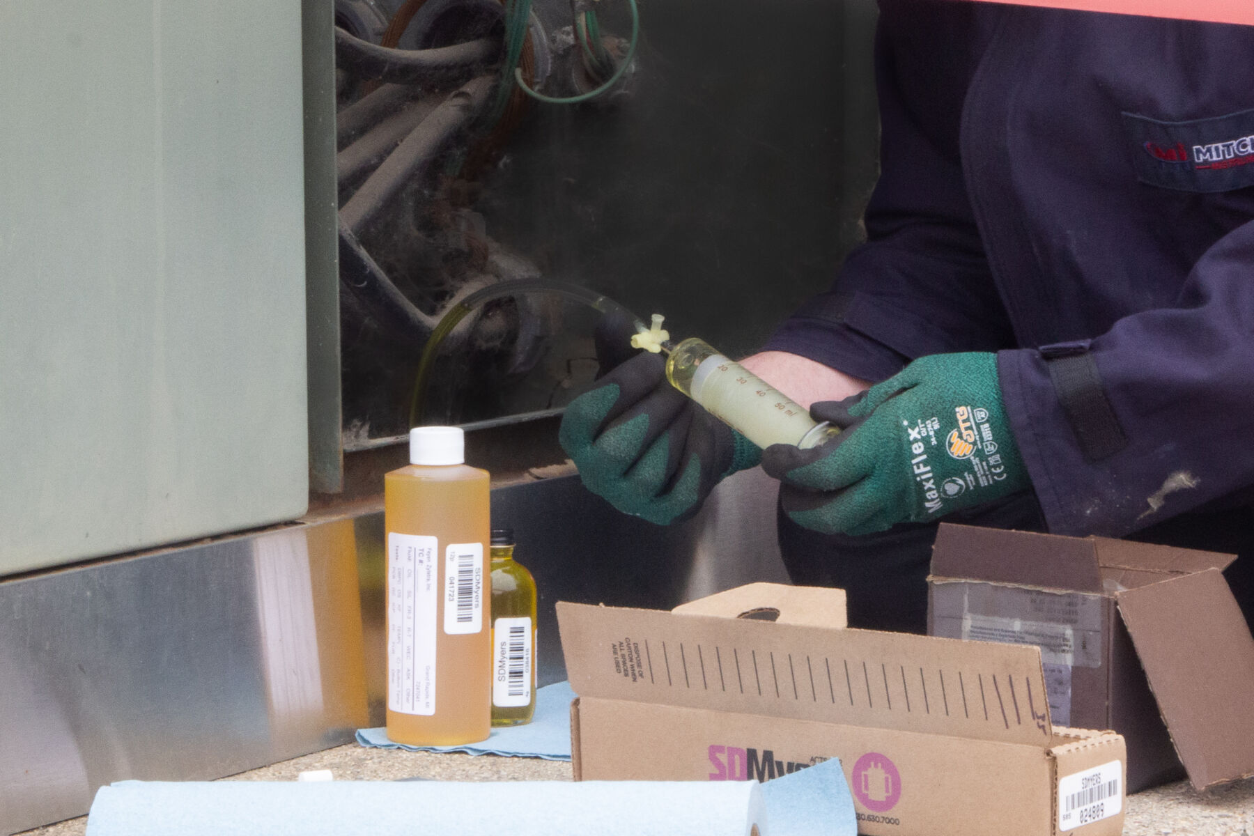 Technician testing oil in a transformer