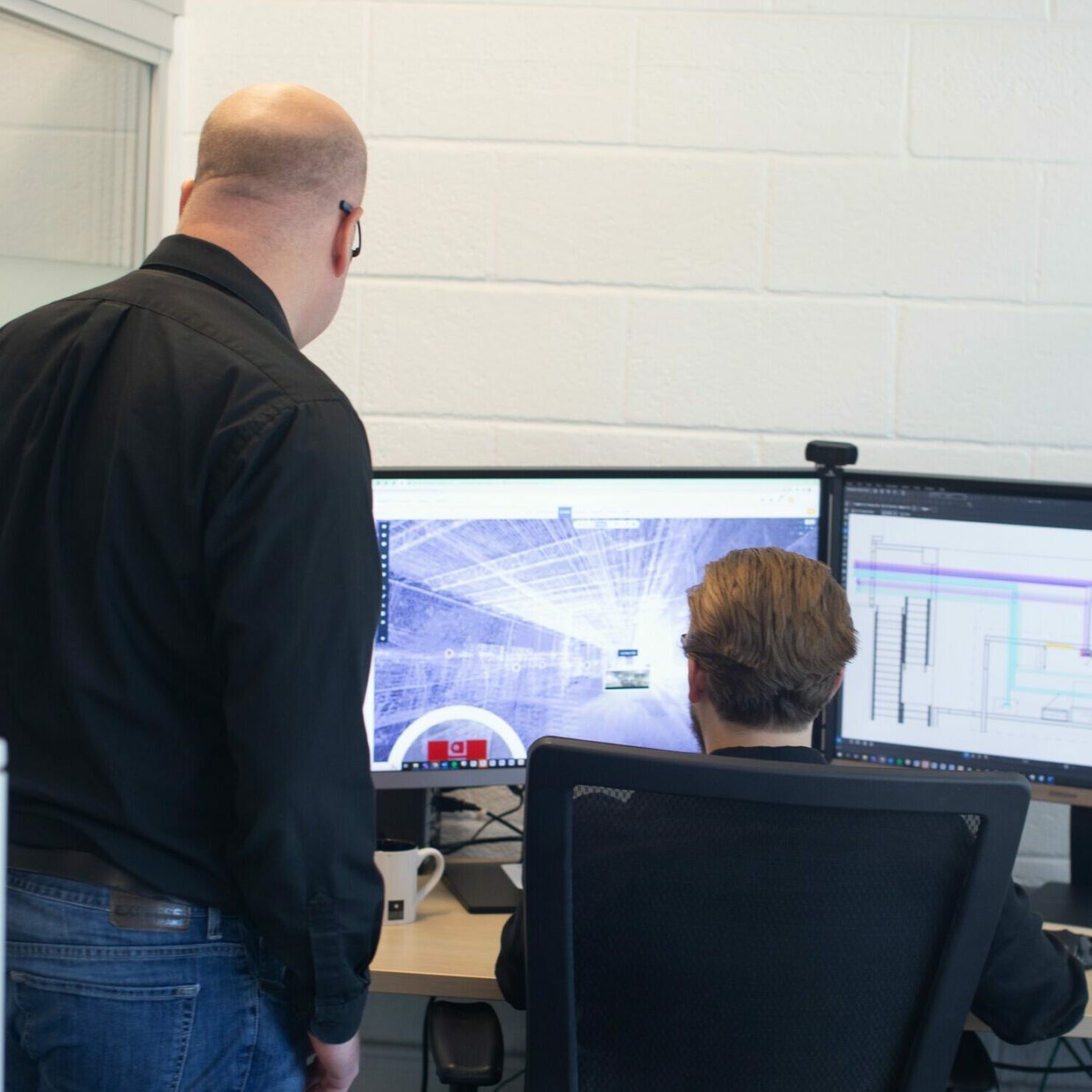 Electrical designers reviewing a scan-to-bim image on a computer