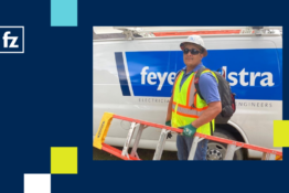 Oliver Osorio wearing PPE and holding a ladder in front of an FZ truck